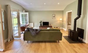 ein Wohnzimmer mit Sofa und Fernseher in der Unterkunft Sancreed House Cottages in Penzance