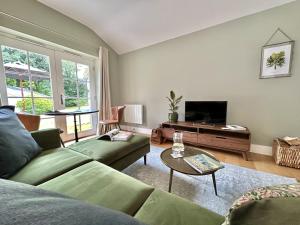 ein Wohnzimmer mit Sofa und Fernseher in der Unterkunft Sancreed House Cottages in Penzance