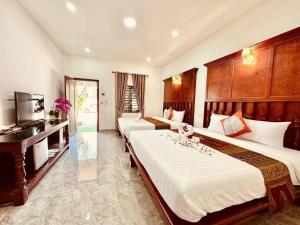 a hotel room with three beds and a television at Pich Mean Bungalow in Sihanoukville