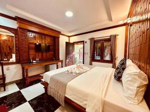 a bedroom with a large bed and a desk at Pich Mean Bungalow in Sihanoukville