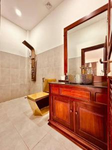 a bathroom with a wooden vanity and a mirror at Pich Mean Bungalow in Sihanoukville