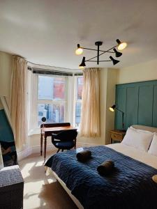 考斯Stylish 1 Bedroom Flat in Heart of Cowes的卧室配有床、书桌和钢琴