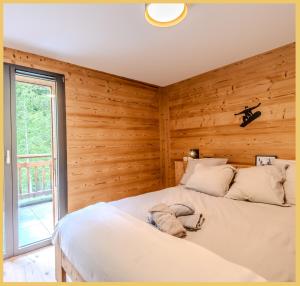 ein Schlafzimmer mit Holzwänden und einem großen Bett in der Unterkunft Le Solaris I Morzine in Morzine