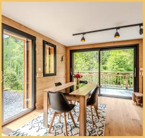 ein Esszimmer mit Tisch und Stühlen und Fenstern in der Unterkunft Le Solaris I Morzine in Morzine