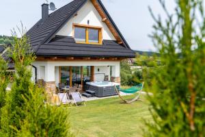 dom z podwórkiem z krzesłami i grillem w obiekcie Czorsztyn Ski&Sail Aparthouse w mieście Maniowy