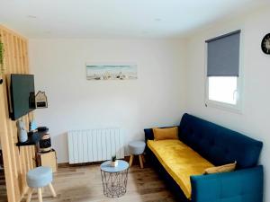 a living room with a blue couch in a room at Les Douglas in Matour
