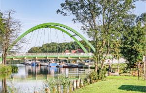 a green bridge over a river with boats at 2 Bedroom Nice Stacaravan In Darlowo in Darłowo