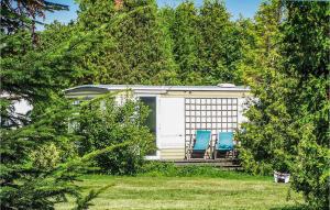 two blue chairs sitting on the porch of a cabin at 2 Bedroom Nice Stacaravan In Darlowo in Darłowo +8 photos