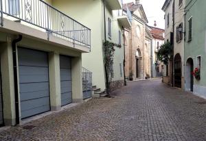 an empty street in an alley with buildings at Casa del barbiere in Dogliani