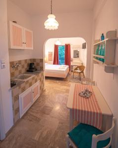 a kitchen with a table and a room with a bed at Stella Studios in Poros
