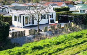 a white house with a tree in a yard at 1 Bedroom Lovely Home In Sint-Annaland in Sint Annaland +16 photos