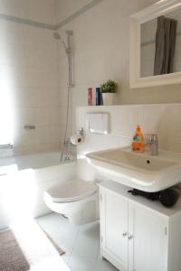 a white bathroom with a toilet and a sink at Cosy Studio, sunny balcony in It-District Neustadt in Dresden