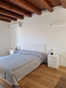 パレルモにあるPalazzo del Buonpastore by Casa Azzurra Apartmentsの白いベッドルーム(ベッド1台付)と木製の天井が備わります。