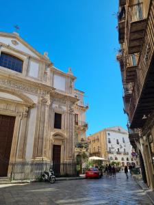 パレルモにあるPalazzo del Buonpastore by Casa Azzurra Apartmentsの通りに駐車された赤い車のある大きな建物