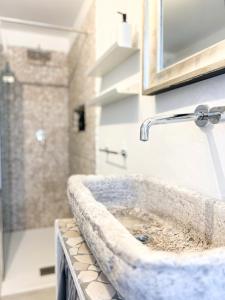 y baño con lavabo de piedra y ducha. en ComeCasa Langhe Garden House-Pace e Panorama a Benevello, en Benevello