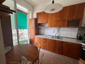 a kitchen with wooden cabinets and a wooden table at Casa Rosy Como Historic Centre in Como
