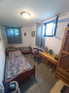 a bedroom with a bed and a desk and a table at Villa Velika GR in Velika