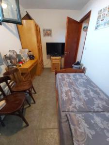 a bedroom with a bed and a desk and a television at Villa Velika GR in Velika