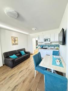 a living room with a black couch and a table at Vila Kraljica 2 - apartman 7 in Vrdnik