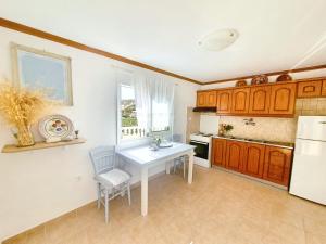 a kitchen with a white table and a white refrigerator at Esperos in Diafani