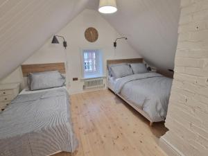 a attic bedroom with two beds and a window at Victorian Villa, Hunstanton Norfolk Sleeps 20 in Hunstanton