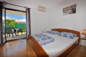 ein Schlafzimmer mit einem Bett und ein Balkon mit einem Tisch in der Unterkunft Apartments Dulabic in Poreč