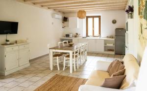 a kitchen and living room with a table and a couch at Il Casale in Teulada +50 photos