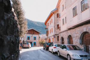 a street with cars parked on the side of a building at Hostal Alto Aragon in Villanúa