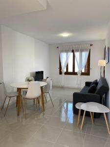Una sala de estar con un sofá, una mesa y sillas. en Aldeas Taray Admer 003, en La Manga del Mar Menor