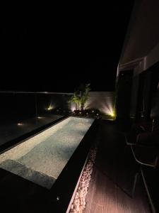 a swimming pool at night with a table and chairs at Apec Mandala Chambay Mũi Né in Ấp Thiẹn Ái