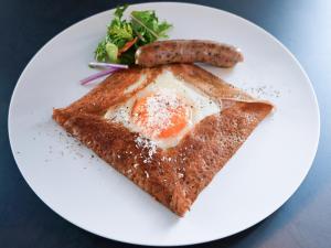 a plate of food with an egg and a sausage at WeBase KAMAKURA in Kamakura