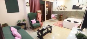 ein Wohnzimmer mit einer Couch und einem Sessel in der Unterkunft Modern Jacuzzi Spa Tub 1BHK Suite South Delhi (3) in Neu-Delhi