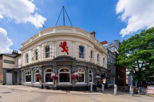 a building with a red sign on the front of it at OYO The Red Lion Hotel in Luton