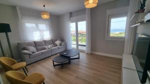 ein Wohnzimmer mit Sofa und Tisch in der Unterkunft Casa Aios in Sanxenxo