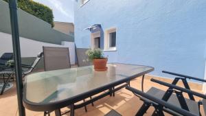 einen Glastisch mit einer Topfpflanze auf dem Balkon in der Unterkunft Casa Aios in Sanxenxo