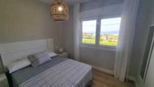 ein weißes Schlafzimmer mit einem Bett und einem Fenster in der Unterkunft Casa Aios in Sanxenxo