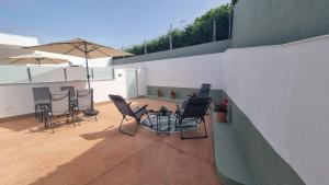 eine Terrasse mit Stühlen, einem Tisch und einem Sonnenschirm in der Unterkunft Casa Aios in Sanxenxo