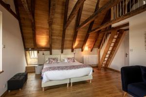 a bedroom with a large bed and wooden ceilings at Chez Mimi - La Petite Maison in Raulhac