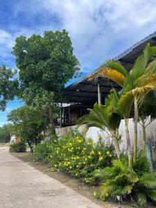 a building with trees and flowers in front of it at Pich Mean Bungalow in Sihanoukville