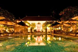 una piscina notturna con sedie e ombrelloni di Orchid 1 BR Quirky Garden Room Single AN17 a Mangsit Altre 10 foto