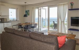 グドイェムにあるAmazing Apartment In Gudhjemのリビングルーム(ソファ付)、キッチン(テーブル付)