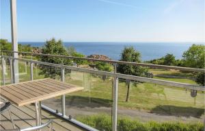 グドイェムにあるAmazing Apartment In Gudhjemの海を見渡すバルコニーに木製のベンチが備わります。 +13枚の写真