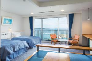a hotel room with two beds and a balcony at Marine Piazza Okinawa in Motobu