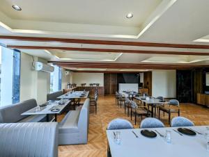 a dining room with tables and chairs and a podium at Hotel Majestic By NxtJen Hospitality in Silvassa