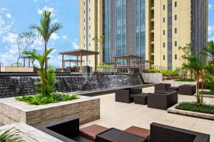 an outdoor patio with chairs and a water fountain at Aether by Kozystay - BSD in Tangerang