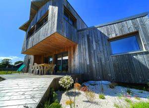 a wooden house with a wooden deck at maison Porzh Loaz. in Plouézec