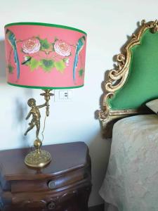 a lamp sitting on a table next to a bed at Soleevino B&B - Exclusively for Adults in Greve in Chianti