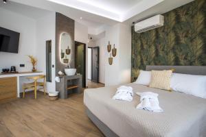a bedroom with a bed with two towels on it at 3K Rodo Rooms in Faliraki