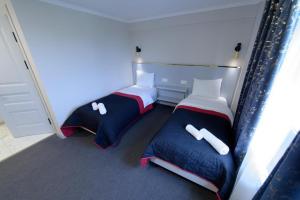 twee bedden in een kleine kamer bij Grand Aura Hotel in Alma-Ata