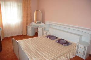 um quarto com uma cama e um toucador com um espelho em Merydian em Yasinia